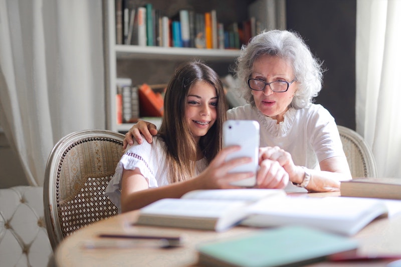 Grandma with her granddaughter looking at smartphone.