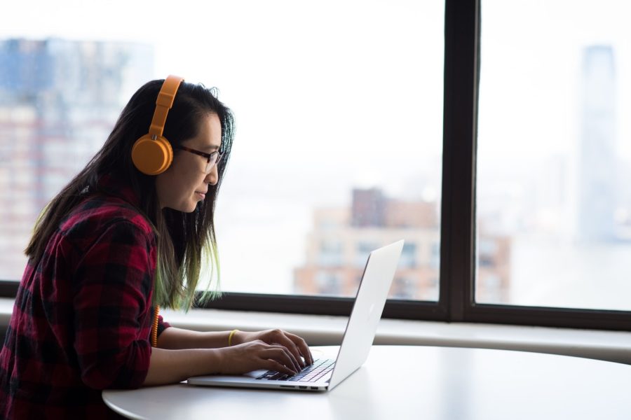 Woman listening to podcast while working from home.