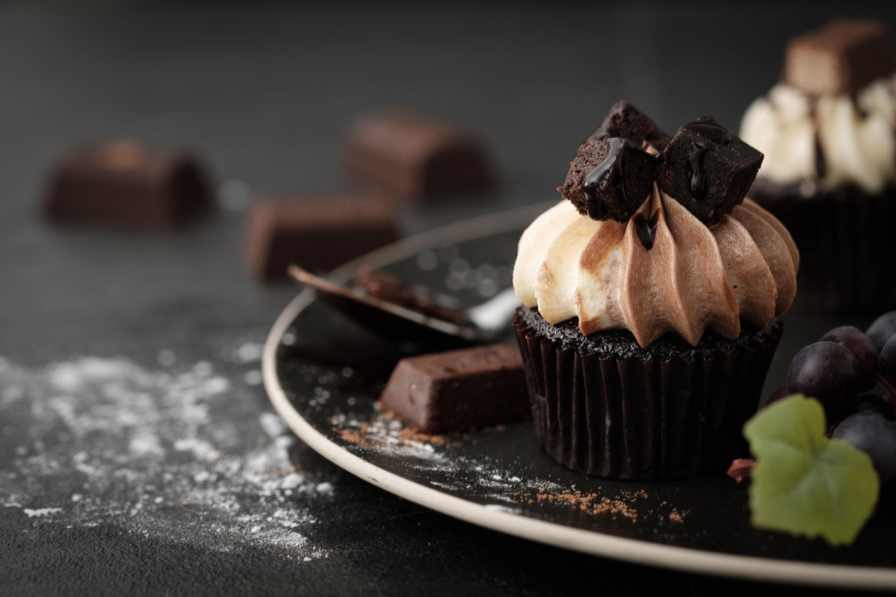 chocolate cupcake with cream frosting on plate