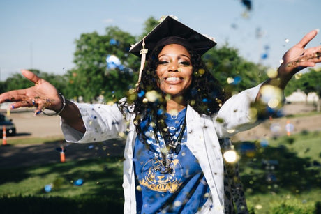 Woman smiling wearing cap and gown for graduation