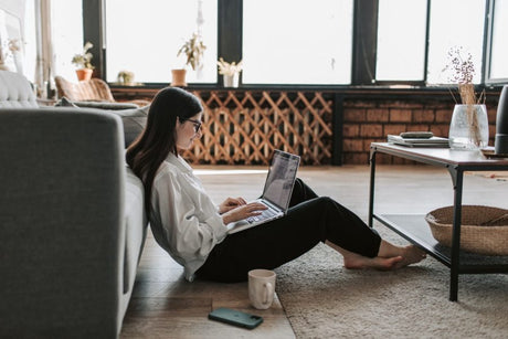 Woman sitting on floor working on laptop